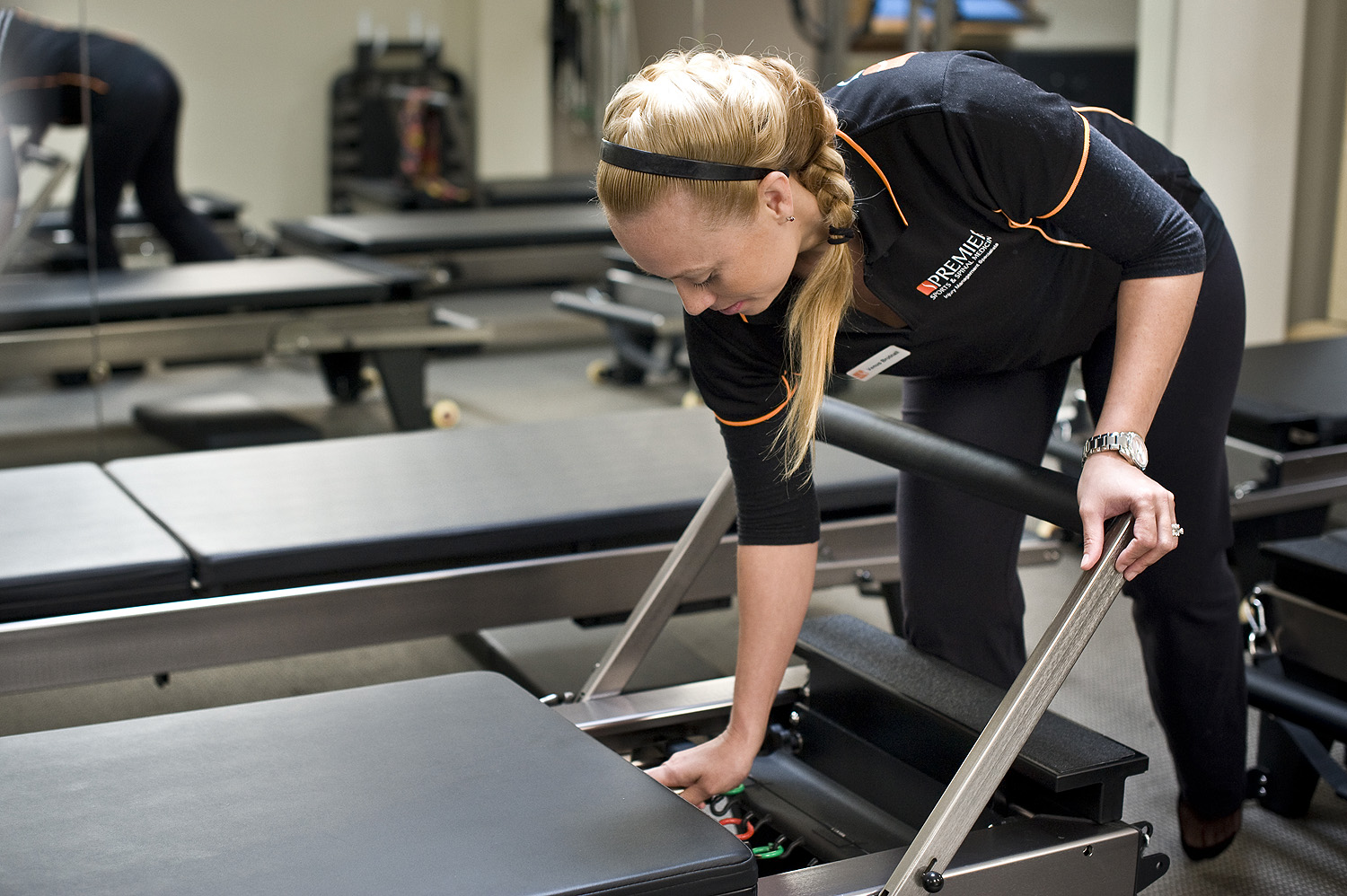 Pilates instructor Venus Brutnall adjusting one of the pilates machines in the studio